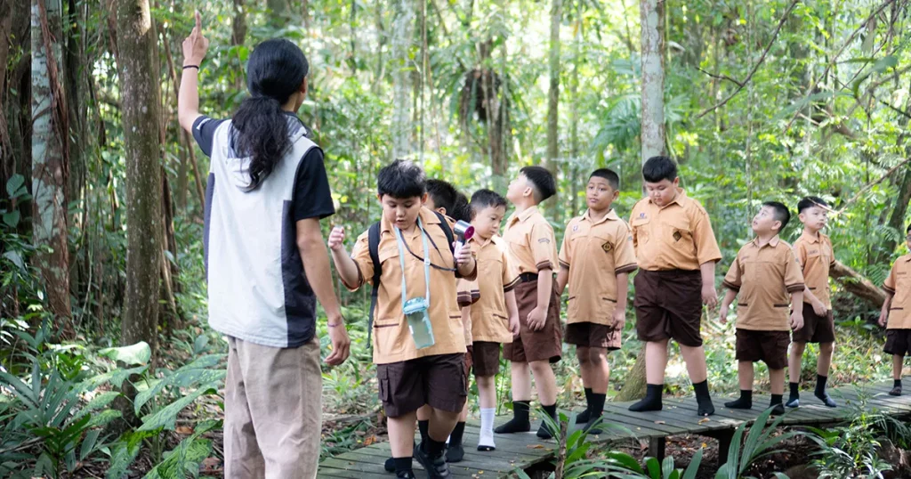 Mahasiswa Fahutan UNTAN memandu siswa SD berjalan sambil menjelaskan ekosistem Arboretum Sylva.