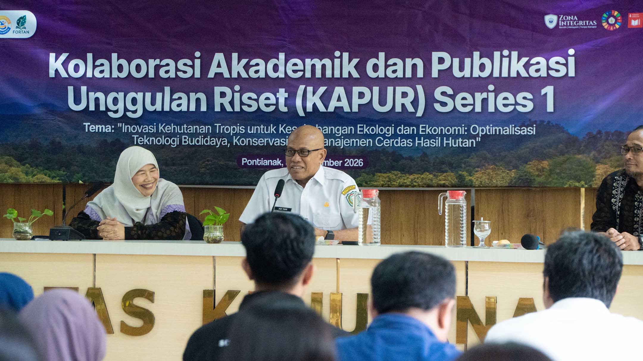 Bapak Adi Yani berbicara menggunakan mikrofon di meja narasumber KAPUR Series 1.