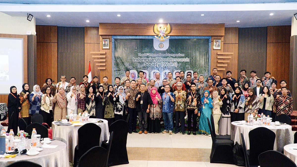 Peserta IWoRS XVIII berfoto bersama di depan latar acara dalam ruang pertemuan University Club UGM.