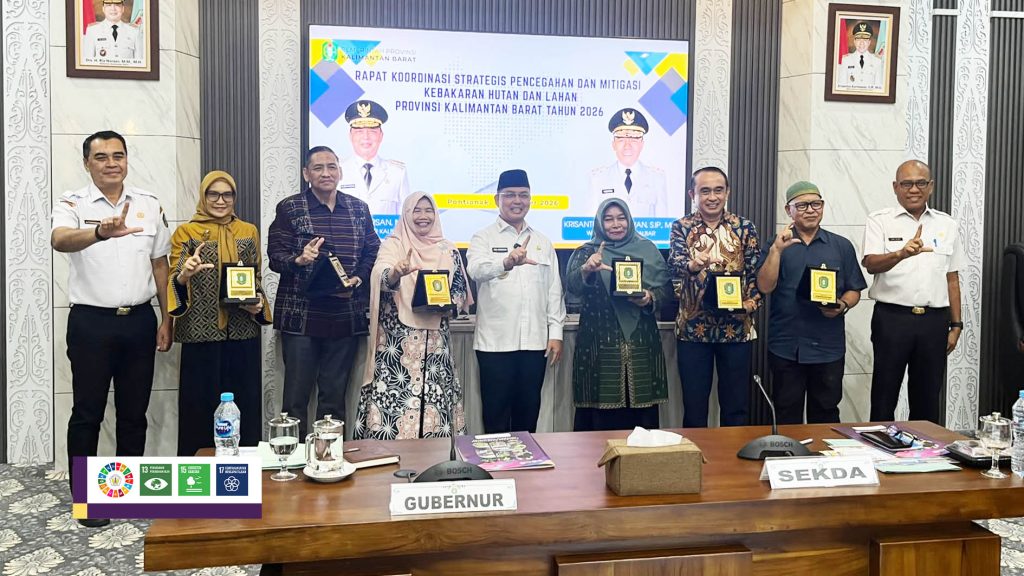 Peserta rapat berfoto bersama di depan layar bertuliskan Rapat Koordinasi Strategis Pencegahan dan Mitigasi Kebakaran Hutan dan Lahan Kalimantan Barat 2026.