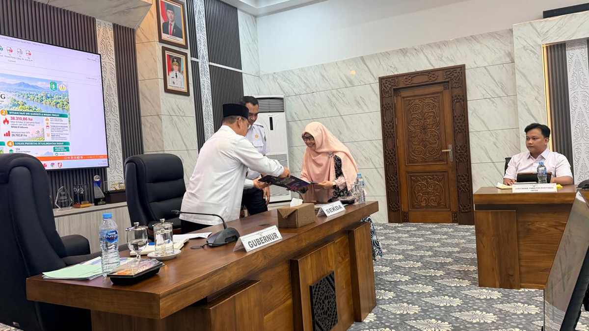 Prof. Farah Diba menyerahkan dokumen policy brief kepada Bapak Ria Norsan di depan meja rapat.