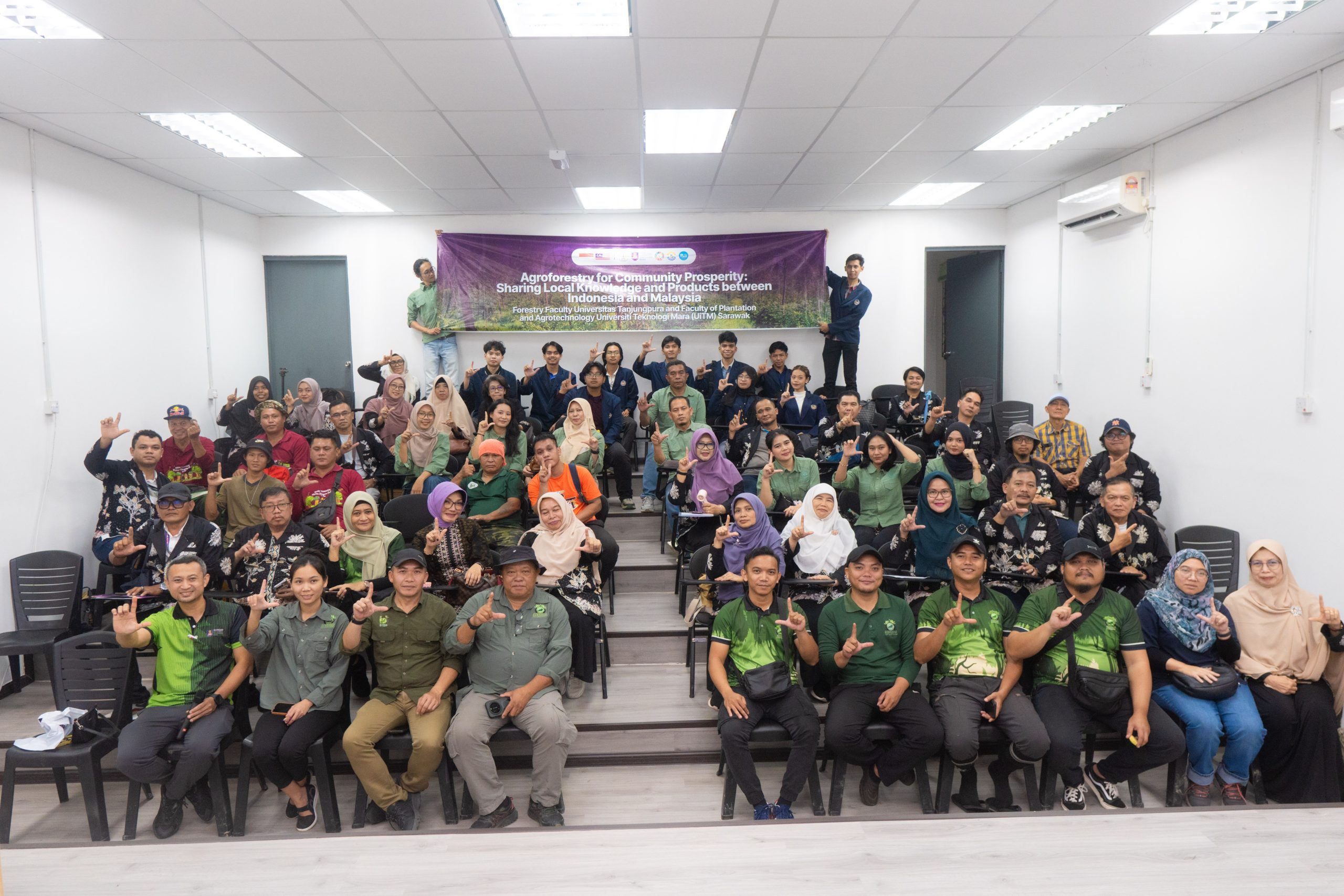 Peserta berfoto bersama di ruang pertemuan dengan spanduk Agroforestry for Community Prosperity di bagian belakang.